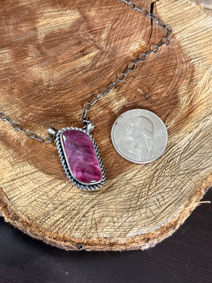 Silver-tone 18-inch necklace with purple spiny oyster oval pendant; shown with coin