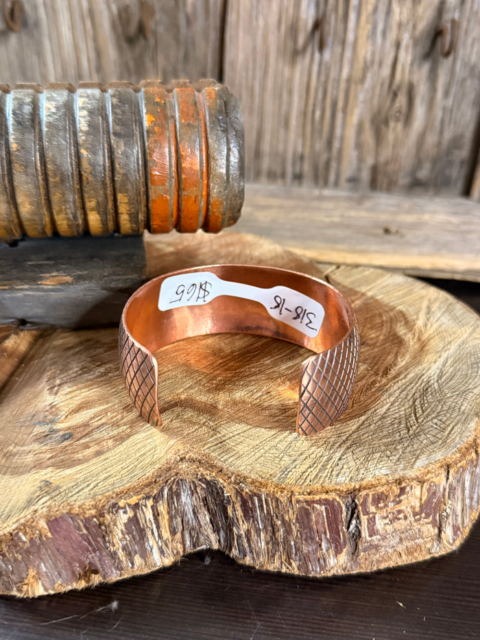 Copper cuff bracelet with hammered diamond pattern and stamped inside