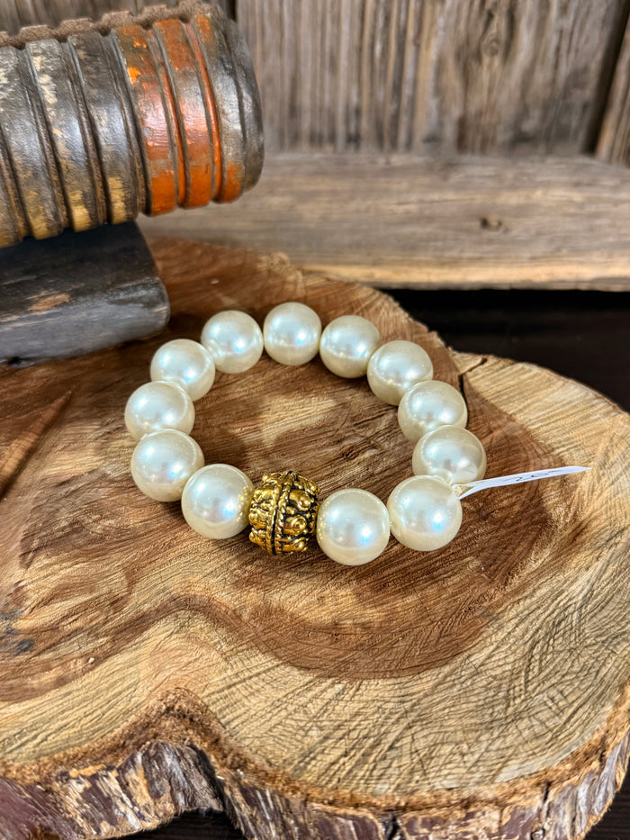 Pearl stretch bracelet with round iridescent beads and gold ornate center charm