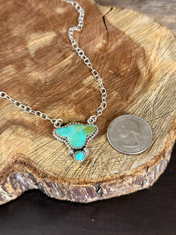 Turquoise cowhead pendant necklace with sterling silver chain, coin scale visible