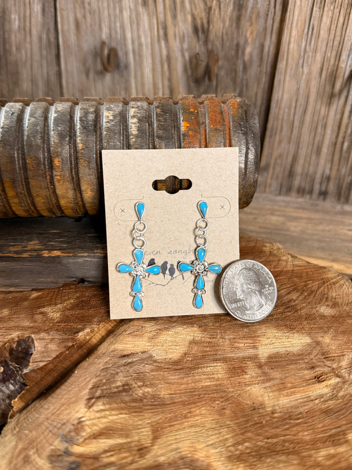 Turquoise cross stud earrings with blue teardrop charms; coin shows scale