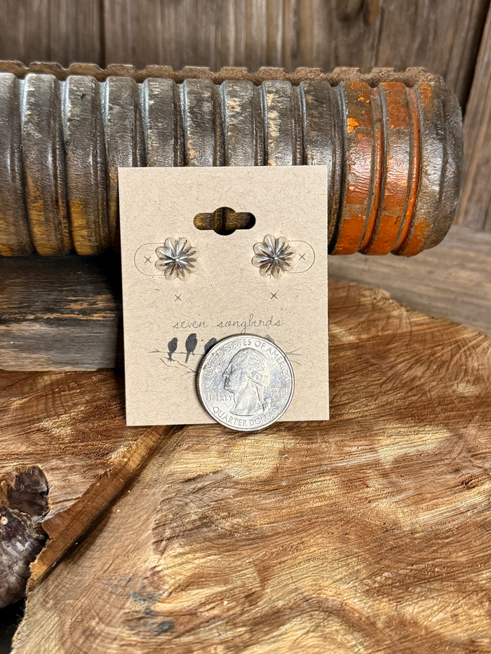 Sterling silver stud earrings with starburst flower design, size shown with coin