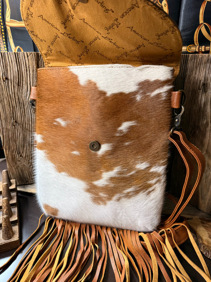 Cowhide crossbody purse with brown-and-white hair-on-hide flap and round snap