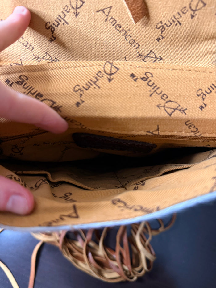 Crossbody purse interior lining with printed American Darling text and tan fringe trim
