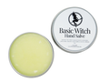 Circular tin containing hand salve. Label says Basic Witch Hand Salve.