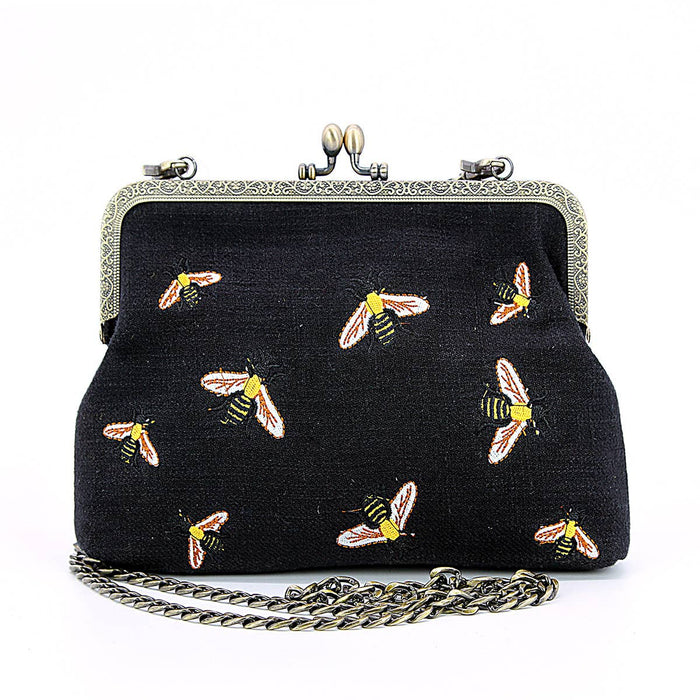 Bees kisslock bag worn as crossbody showing detachable 26 inch chain strap and natural cotton linen blend construction by GoodStuff Co