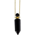 Black pendant necklace with gold chain on a white background