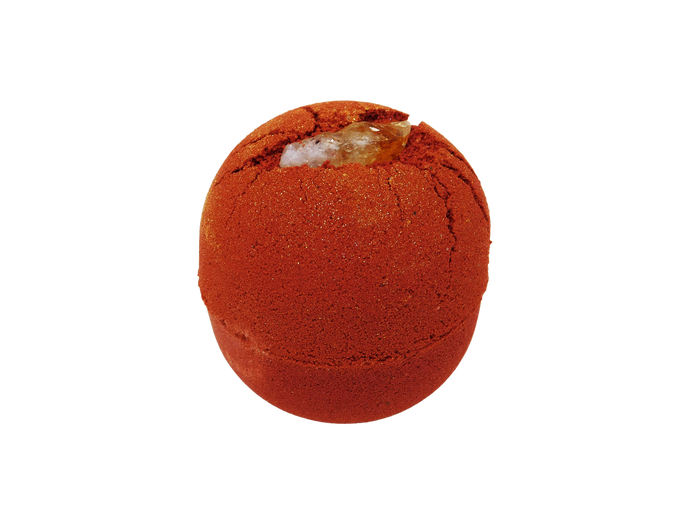 circular red bath bomb witih citrine pressed into it. Topped with gold glitter.