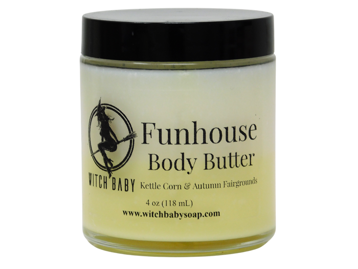 A jar of Witch Baby Funhouse Body Butter with a black lid and a pale yellow body butter visible through the clear glass jar, set against a plain white background.