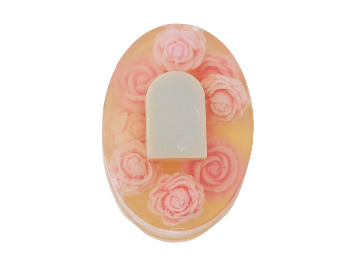 Oval shaped soap with tombstone and rose design. Roses are pink and tombstone is grey.