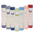 Set of candles with colorful labels and butterfly illustrations on a white background