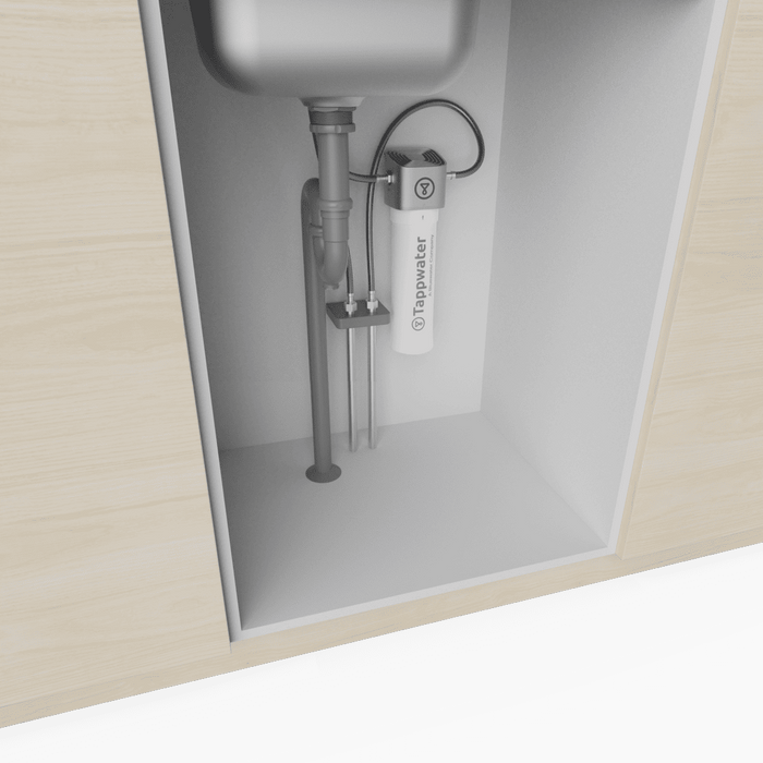 An Inline Filter SMR by Tappwater is installed under the kitchen sink, with pipes and a white cylindrical filter attached to the cabinet wall.