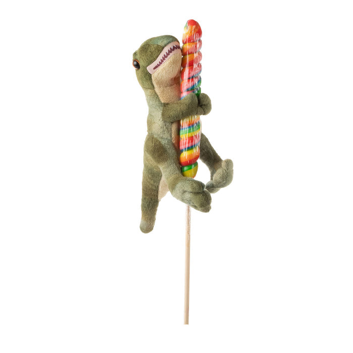 Side view of green Lollyplush T Rex dinosaur plush hugging a multicolor rainbow lollipop on a wooden stick, white background