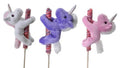 Three Lollyplush unicorn plush toys in white, purple, and pink each hugging a rainbow lollipop on a wooden stick, white background