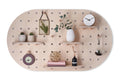large oval shaped wood pegboard with shelves and hooks made by kreisdesign