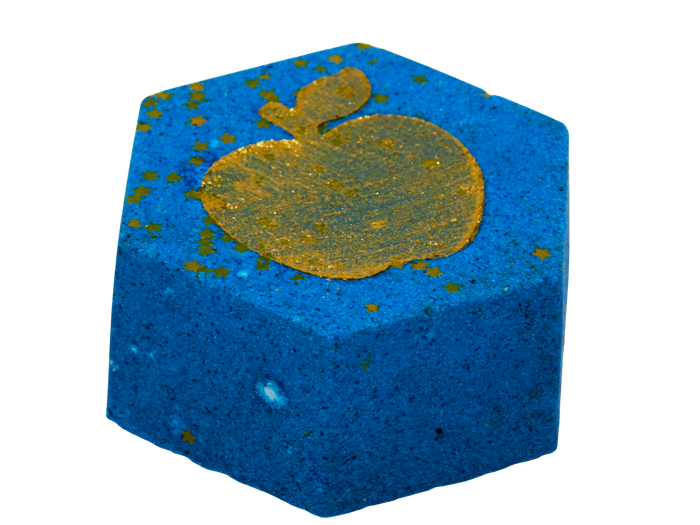 A blue hexagonal bath bomb with a featuring a glittery gold apple design on top and scattered gold flecks.