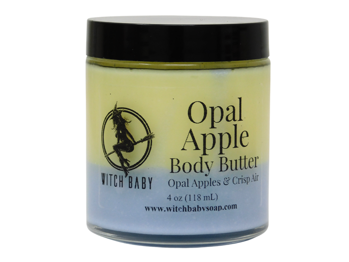 A jar of Witch Baby Opal Apple Body Butter with a black lid and a label showing a witch graphic, on a white background.