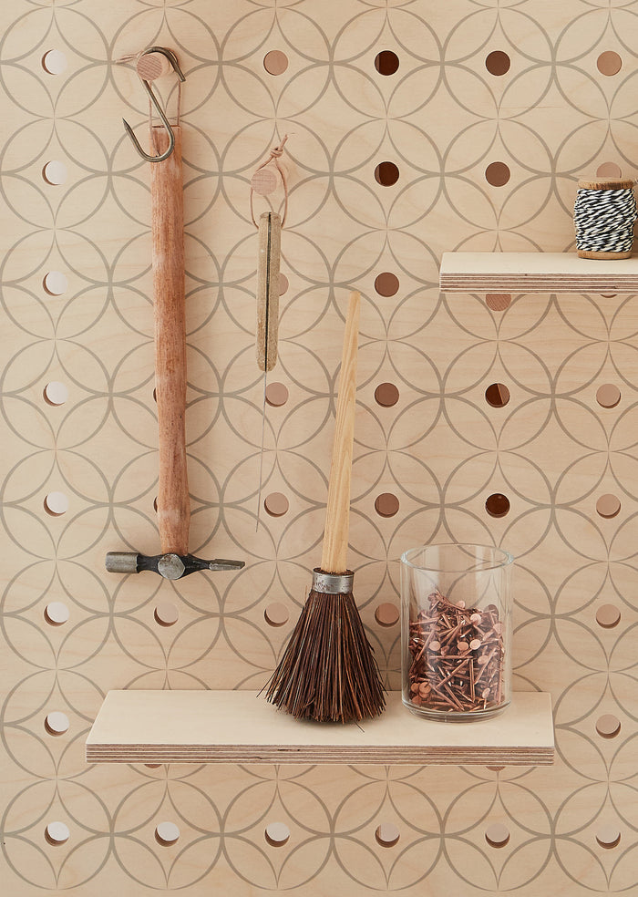 hanging hammer and nails on wooden pegboard with wooden shelf and solid pegs