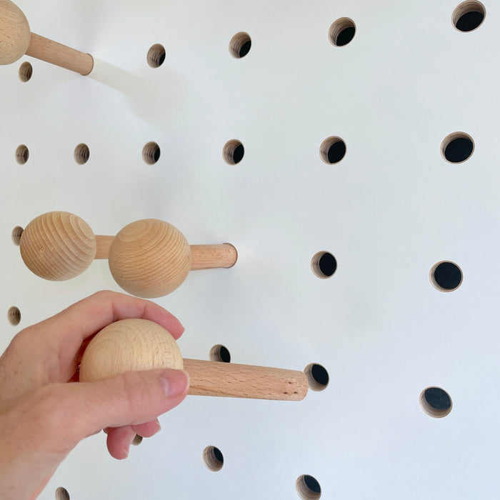 white wooden pegboard with solid beech round peg for hanging coats, bags etc on Kreisdesign pegboards