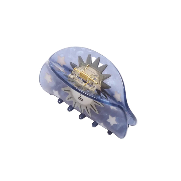 Blue hair clip with star and moon design on a white background