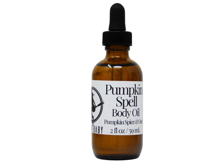 A 2 fl oz amber glass dropper bottle of Baby Pumpkin Spell Body Oil with a black dropper cap and a white label, isolated on a white background.