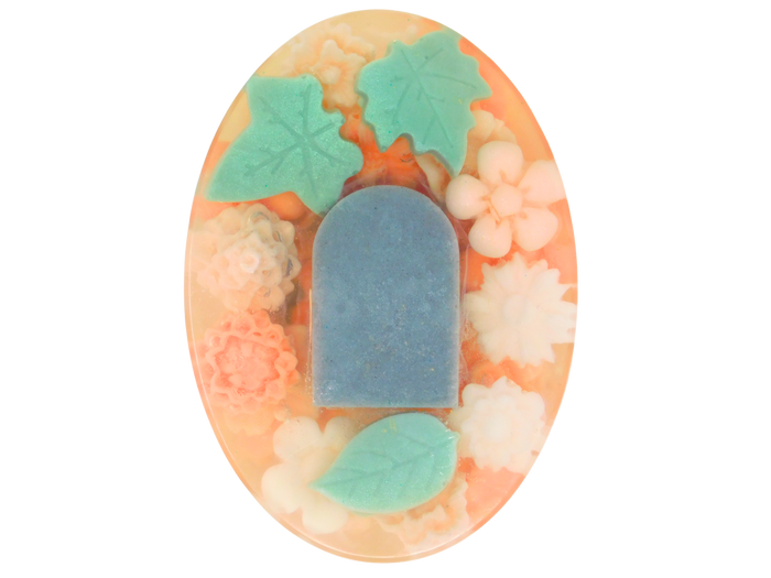Decorative soap with a headstone and green leaves and peach colored flowers