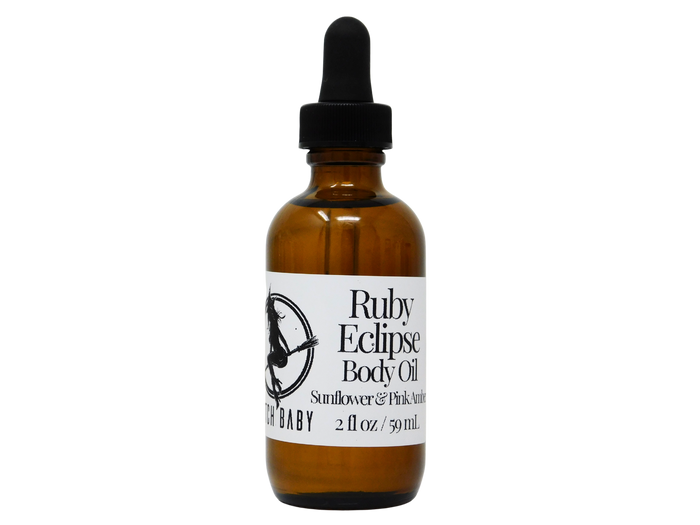 Brown glass bottle with dropper labeled 'Ruby Eclipse Body Oil' on a white background