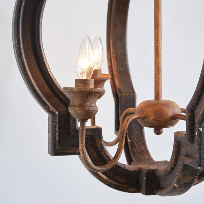 Rustic farmhouse bird cage pendant lamp in distressed metal finish with three candelabra bulb holders, hanging by decorative chain close up candle light