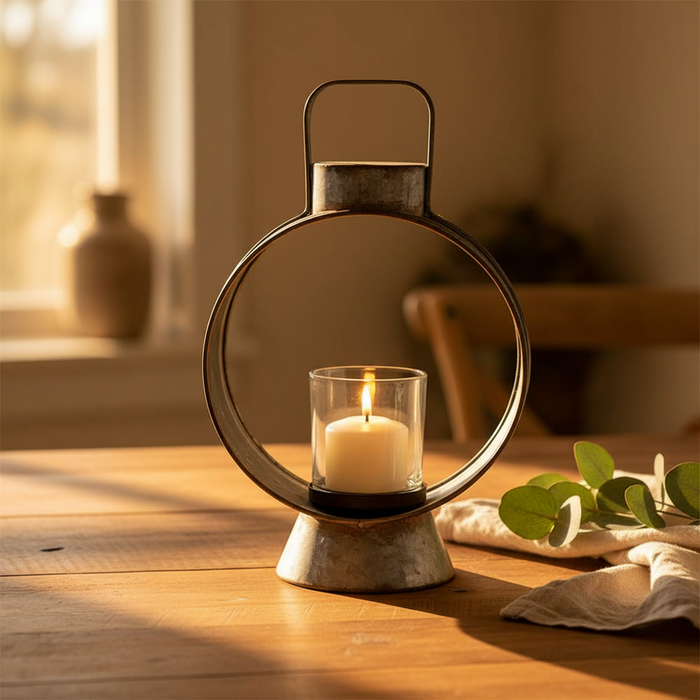 Small workman's lantern on a warm honey-toned wood surface with eucalyptus sprig and linen cloth, soft golden afternoon light