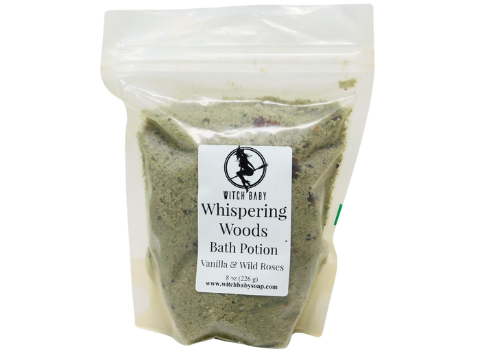 clay and salt bath potion packaged in 8 ox compostable plastic bag that reads: whispering woods bath potion - vanilla & wild roses