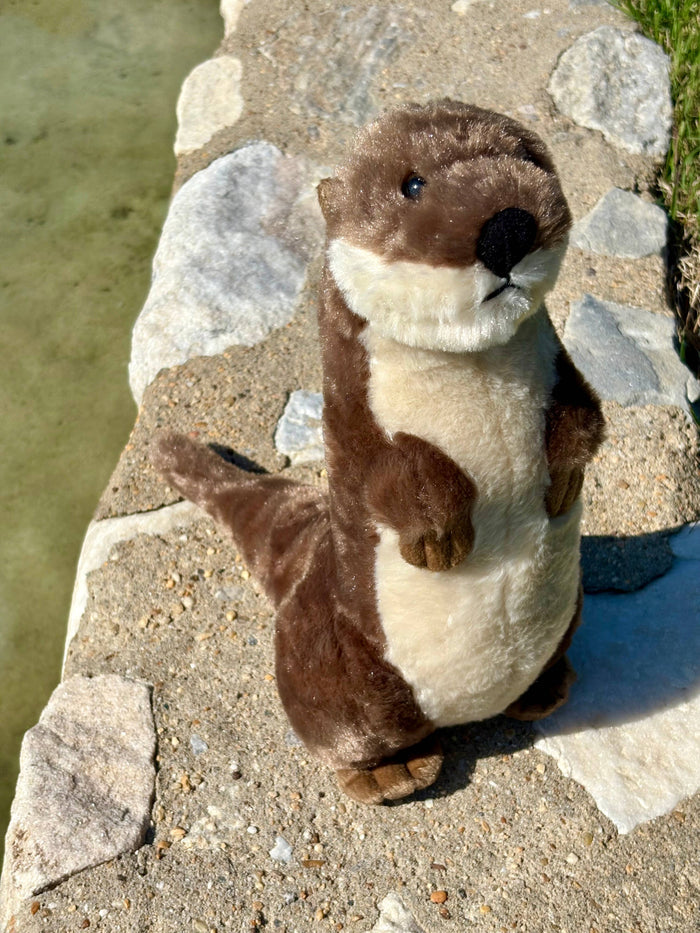 Side view of Wild Onez river otter plush standing tall showing full brown body, cream belly, and small front paws, white background