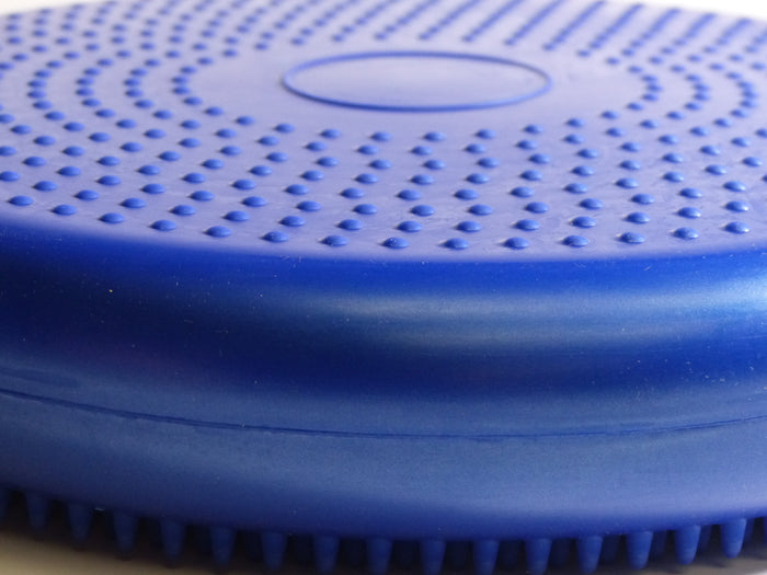 Round blue plastic cushion filled with air, with bumpy sides for grip and massage use. For standing on to improve balance, stability and core strength